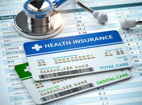 Stethoscope and health insurance cards on medical chart.