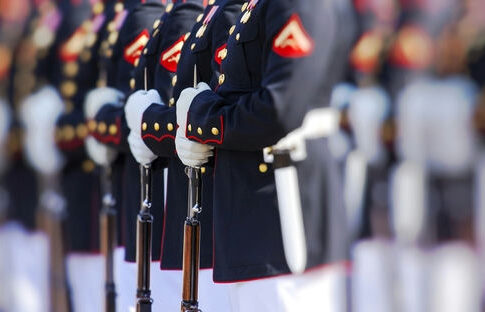 Military officers standing in formation holding rifles.