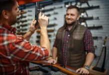 Virginia Governor DEFIES Feds—Midnight Ban Triggers War… Two men examining a handgun in a gun shop.