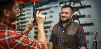 Two men examining a handgun in a gun shop.