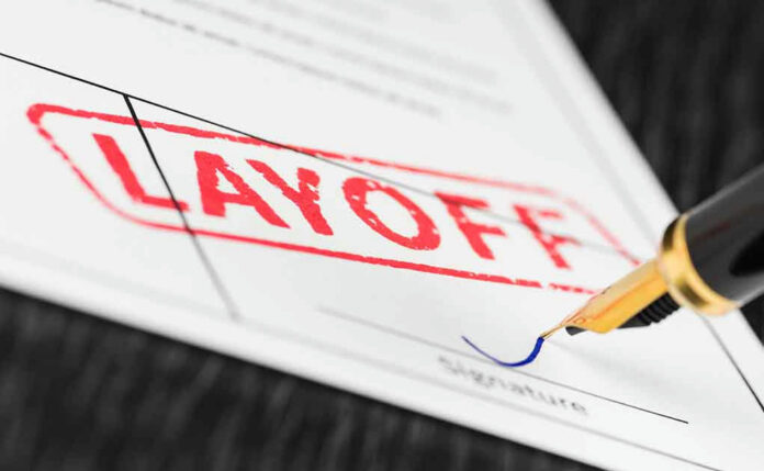 Layoff notice being signed with a pen.