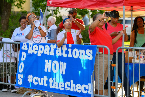 Protesters holding Reparations NOW banner at rally.