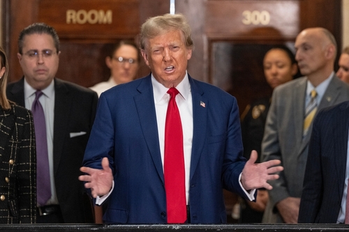 Former,President,Donald,Trump,Speaks,To,The,Press,Before,Closing A public figure speaking at a press conference with a group of people in the background