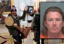 PARDONED Jan 6 Meme Man Demands Millions.. Individual holding a wooden podium inside a historic building during a protest