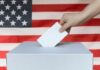 Trump Axes Election Umpires Weeks Before Votes Hand casting ballot into box before U.S. flag