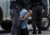 Police officer arresting and handcuffing a person.