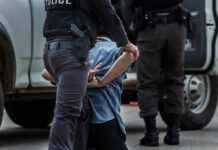 Police officer arresting and handcuffing a person.