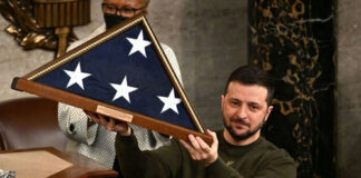 Man holding folded American flag in wooden case.