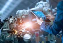 Micron’s Bold Hiroshima Power Play Person using a tablet to monitor robotic machinery.