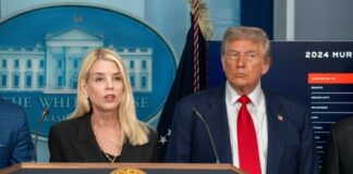 Two government officials at a press conference in front of the White House backdrop