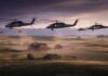 Black Hawks Swarm Missouri Camp Military helicopters fly low over a rural farm at sunset